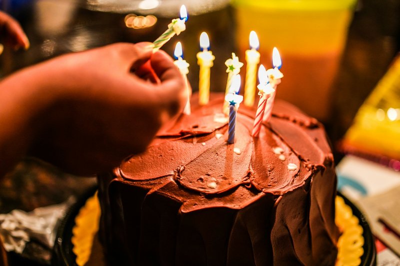 Birthday cake with lit candles at a party in Houston