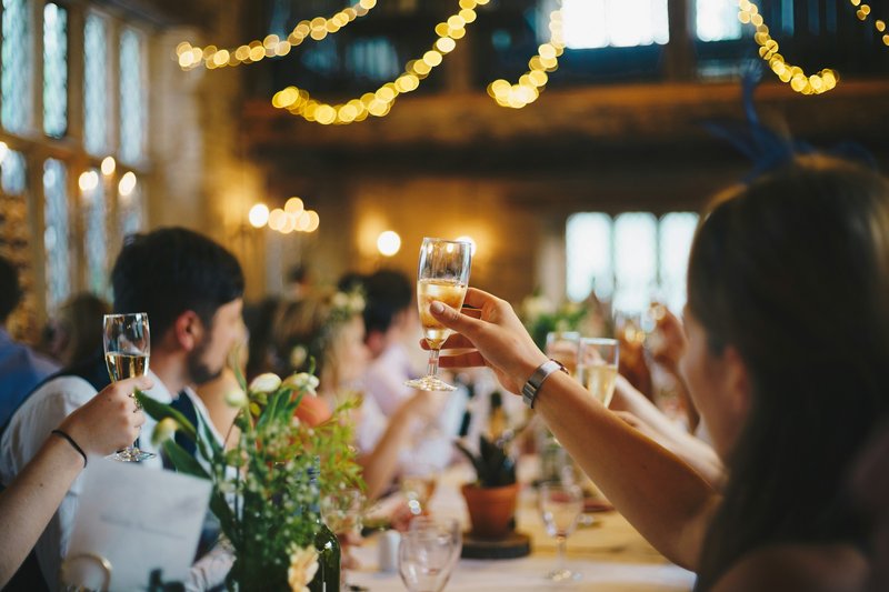 friends holding their glasses up to cheers at a birthday party